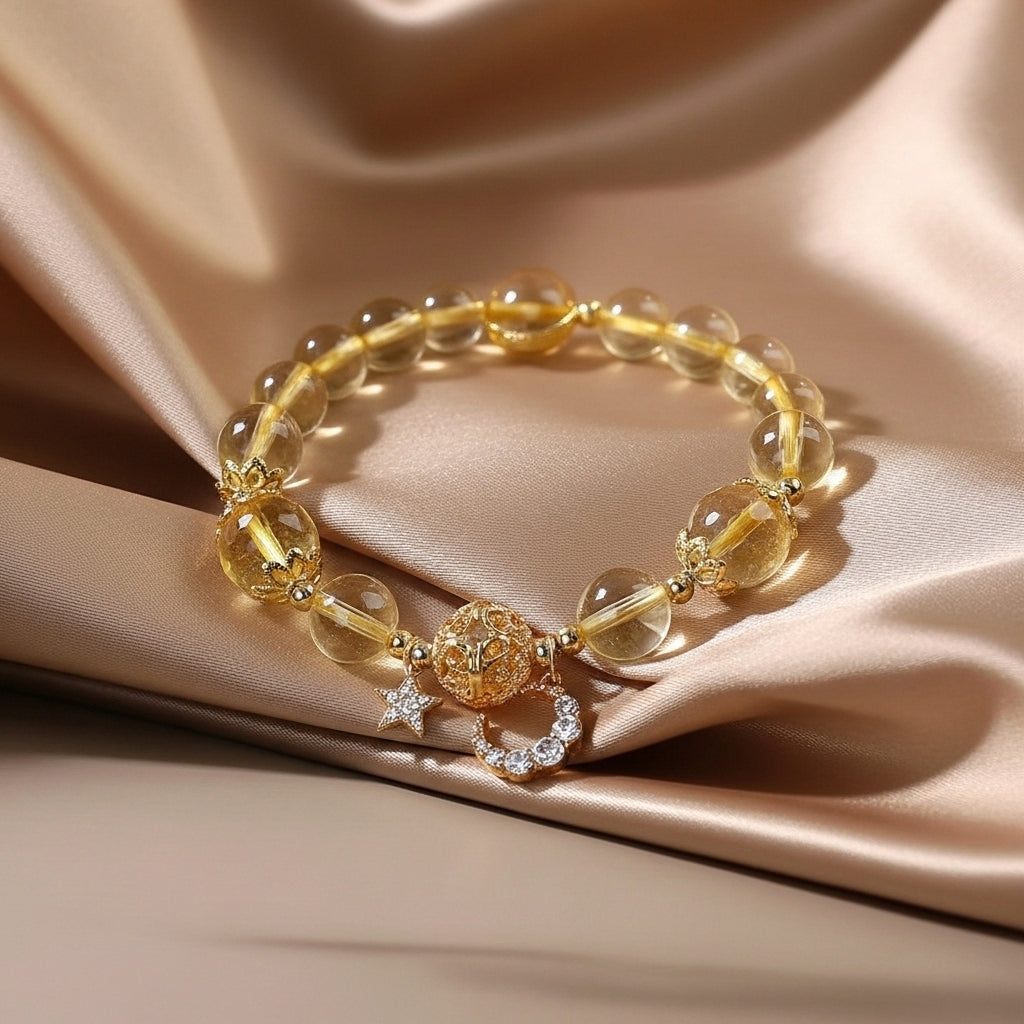 Bracelet en citrine naturelle avec breloques Arbre de Vie et Étoile, orné de cristaux, sur fond satiné doré.