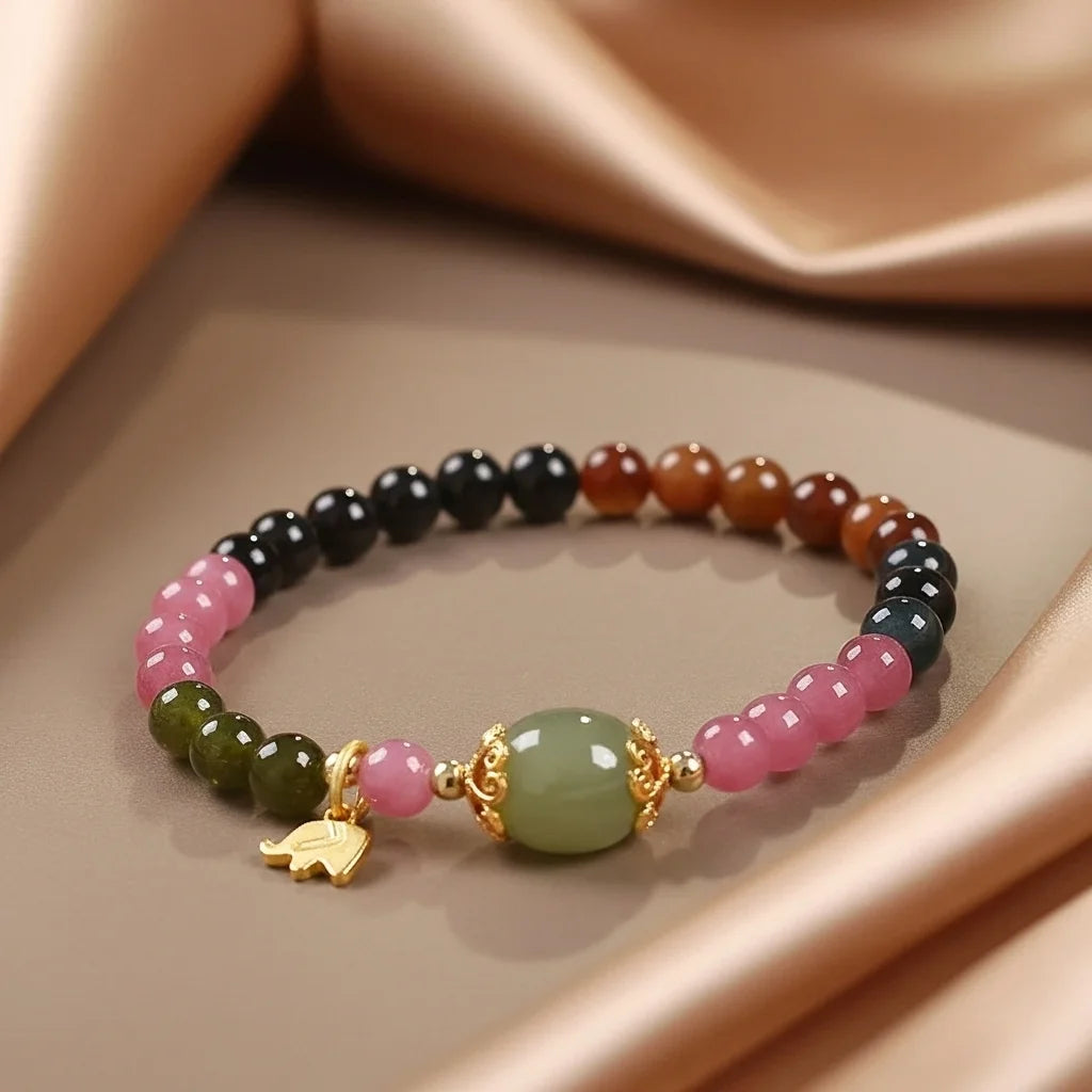 Bracelet "Harmonie" en pierres naturelles de 7 chakras avec breloque éléphant dorée et pierre centrale verte ovale